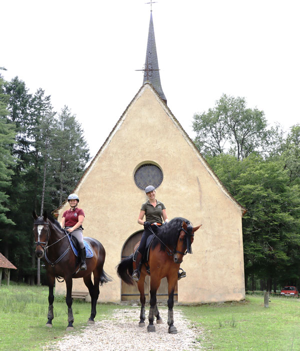 experience-immersion-nature-a-cheval deux femmes à cheval devant l'église du parc naturel de Boutissaint